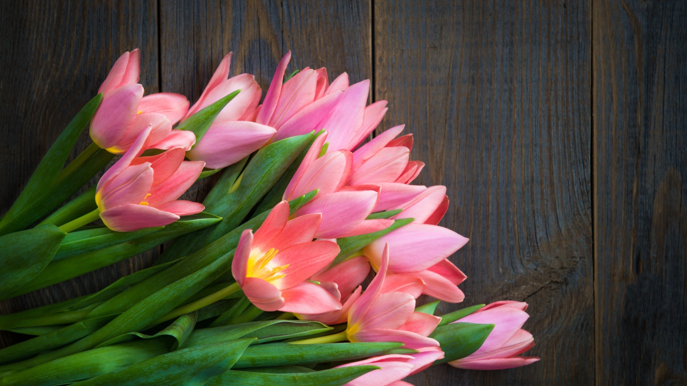 Красивый букет розовых тюльпанов на деревянном столе