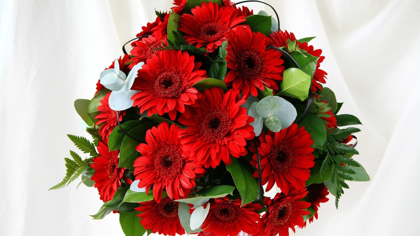 Красивый букет с красными герберами и зелеными листьями 