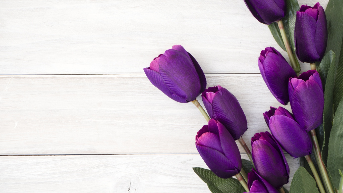 Букет искусственных фиолетовых тюльпанов на деревянном фоне