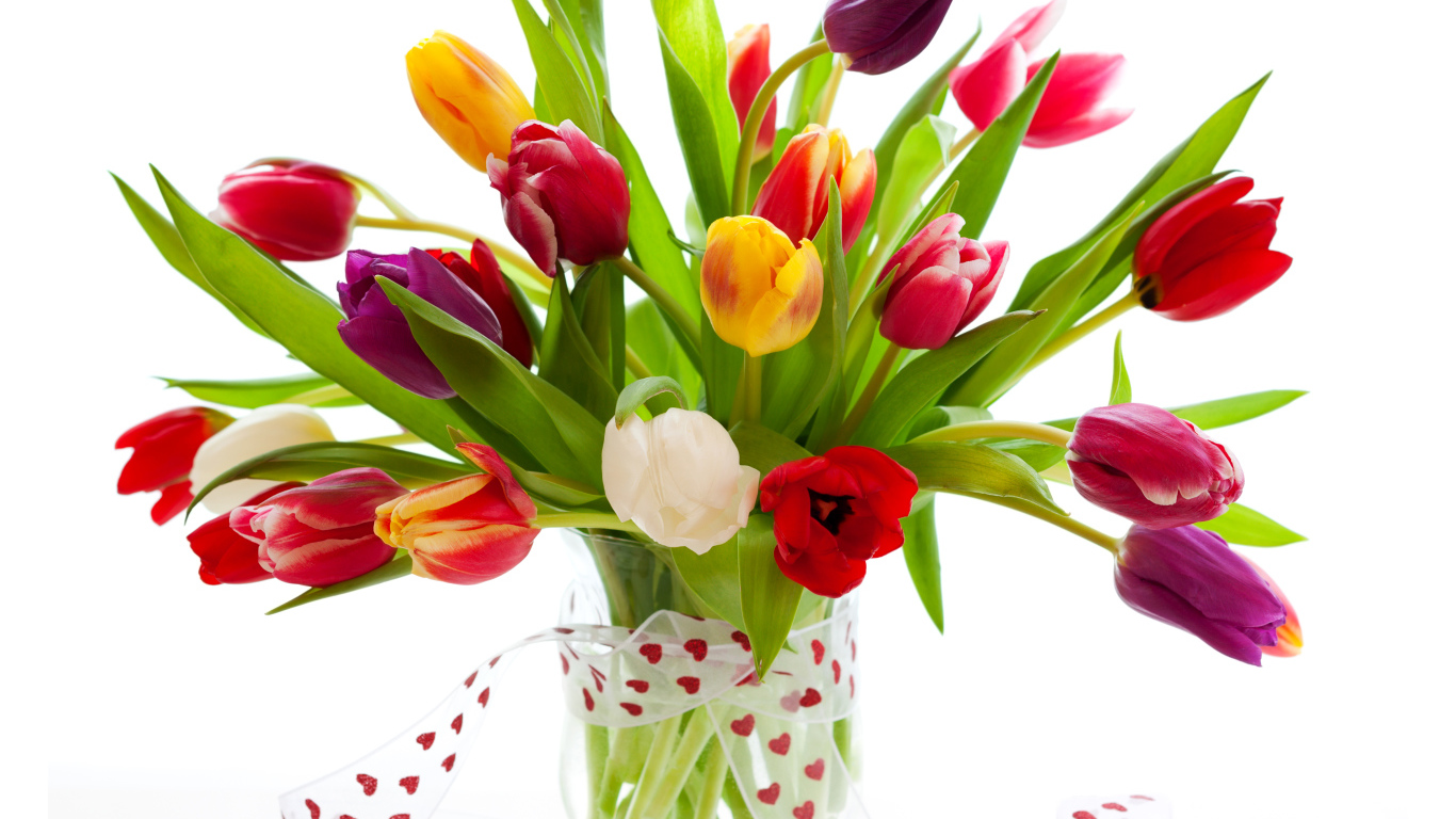 Букет разноцветных тюльпанов в прозрачной вазе с лентой 