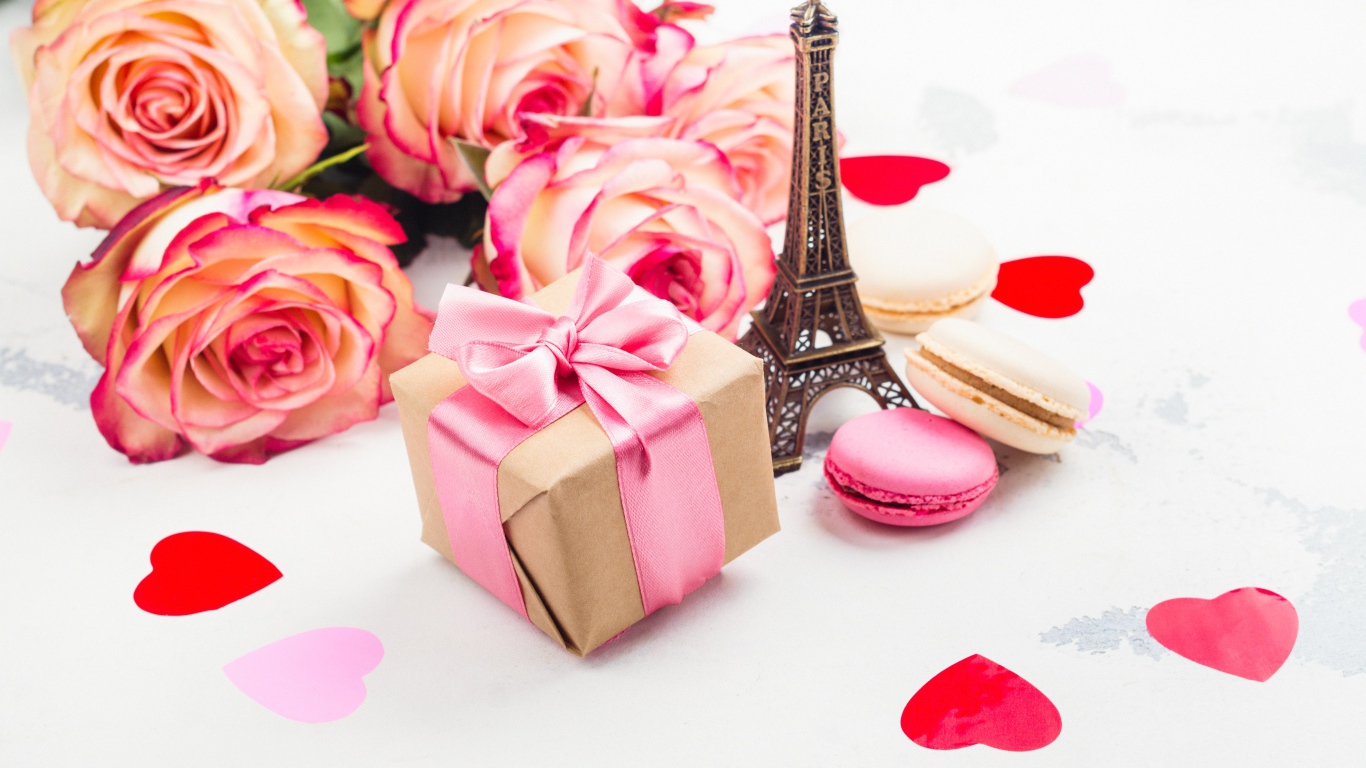 Букет роз на столе с фигуркой Эйфелевой башни и подарком