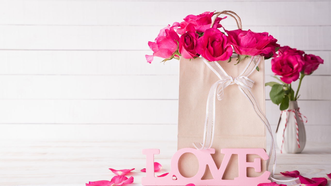 Пакет с розами на столе с надписью Love