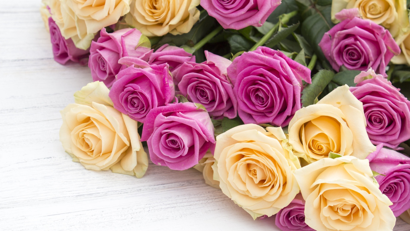 Розовые и белые розы на белом столе 