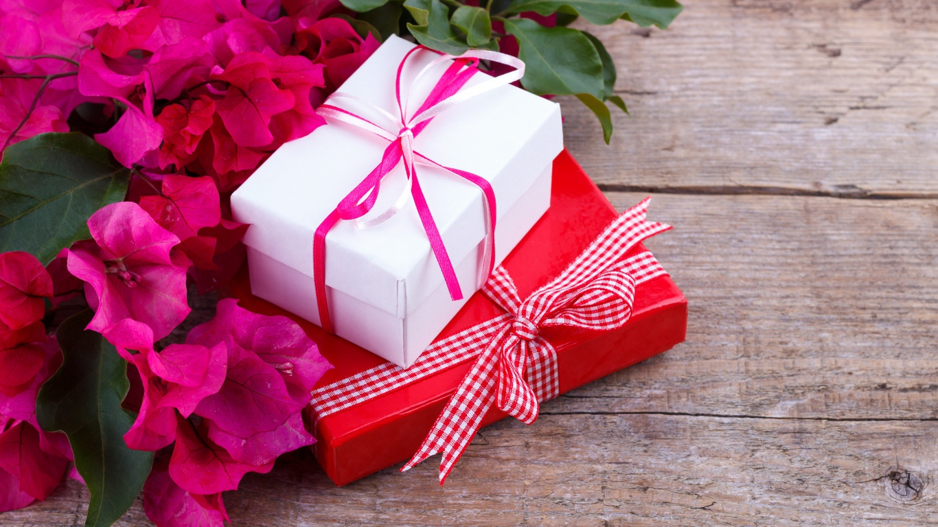 Две коробки с подарками на столе с цветами