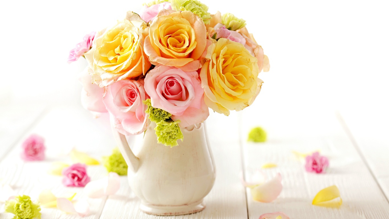 Желтые и розовые розы в вазе на столе 