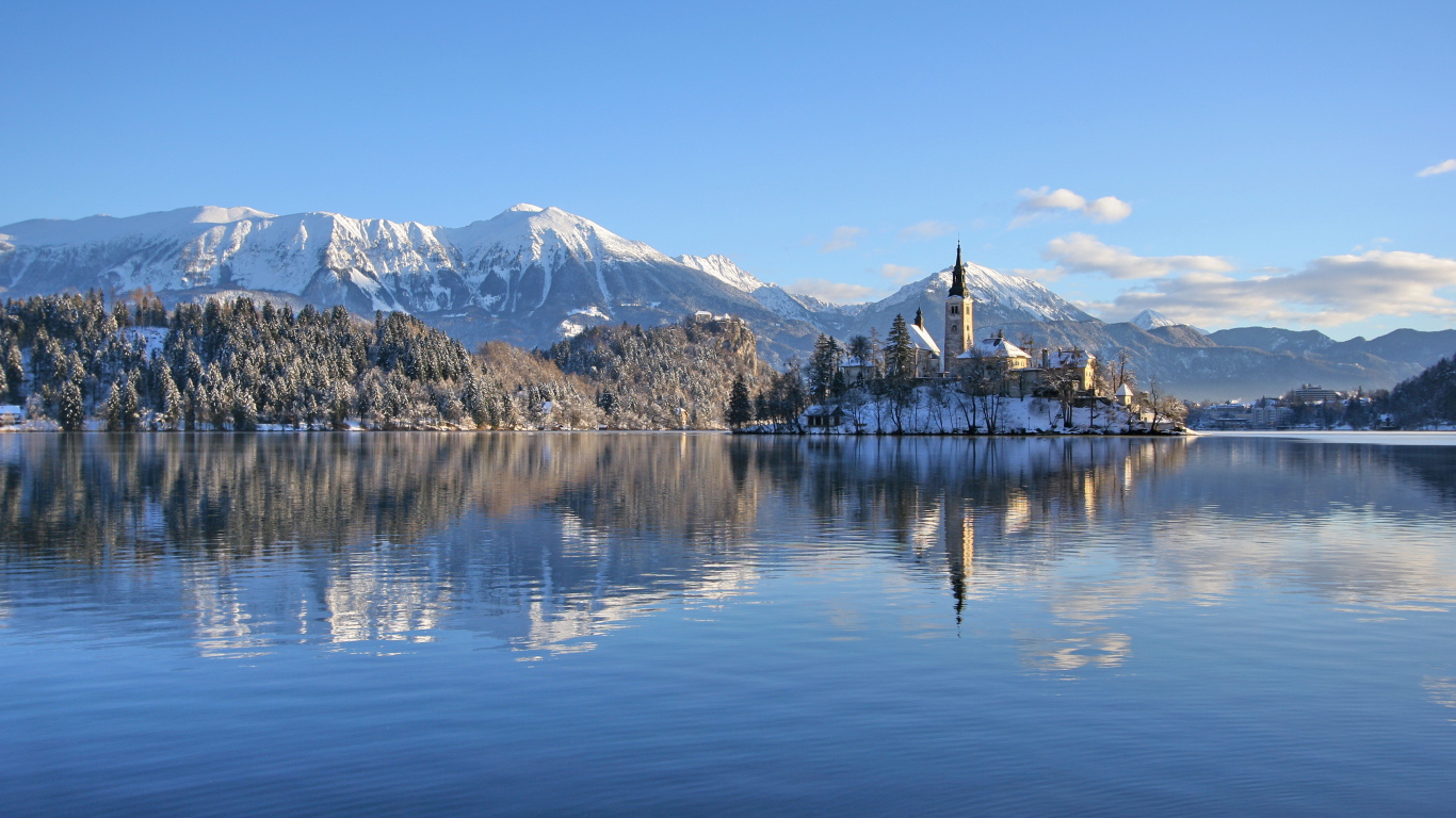 Красивый вид на заснеженные горы и замок у озера 