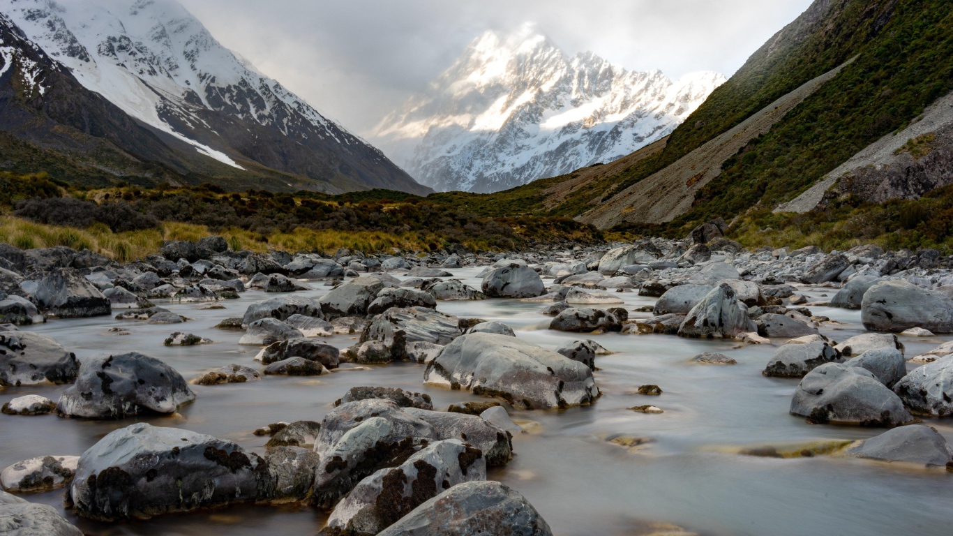 Stones in the water at the snow-capped mountains