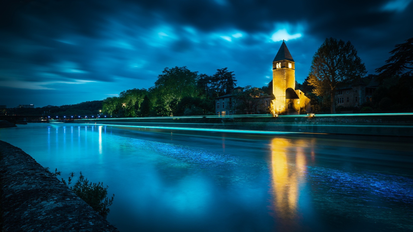 Башня на берегу реки ночью 