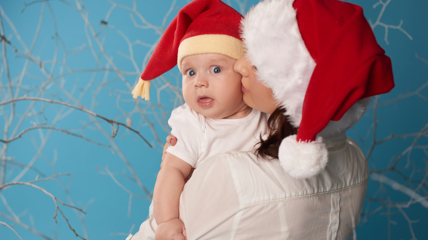 Маленький ребенок в новогоднем костюме на руках у мамы