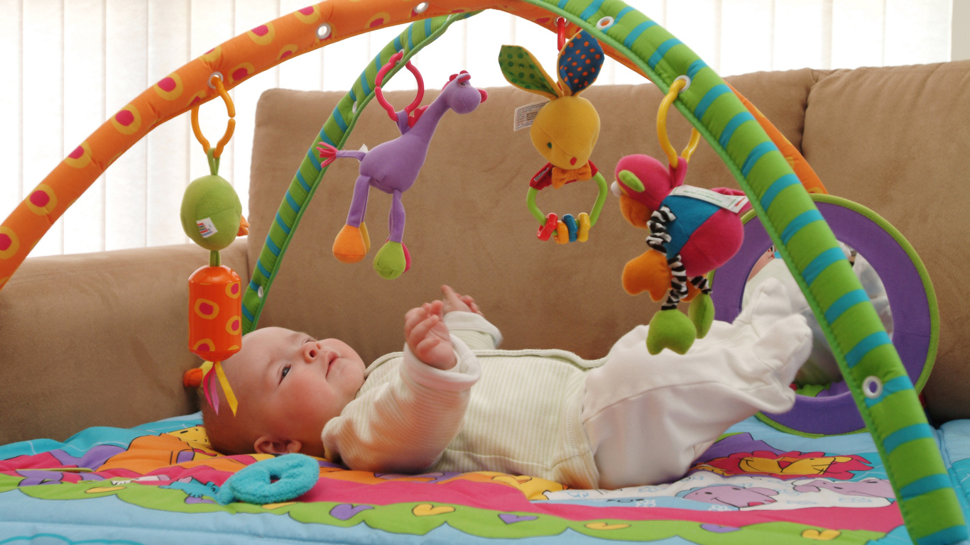 Грудной малыш играет с игрушками