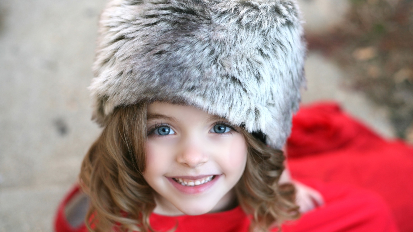 Красивая улыбающаяся девочка в меховой шапке