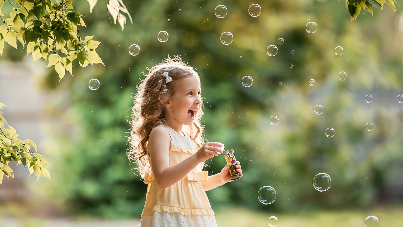 Веселая девочка с мыльными пузырями
