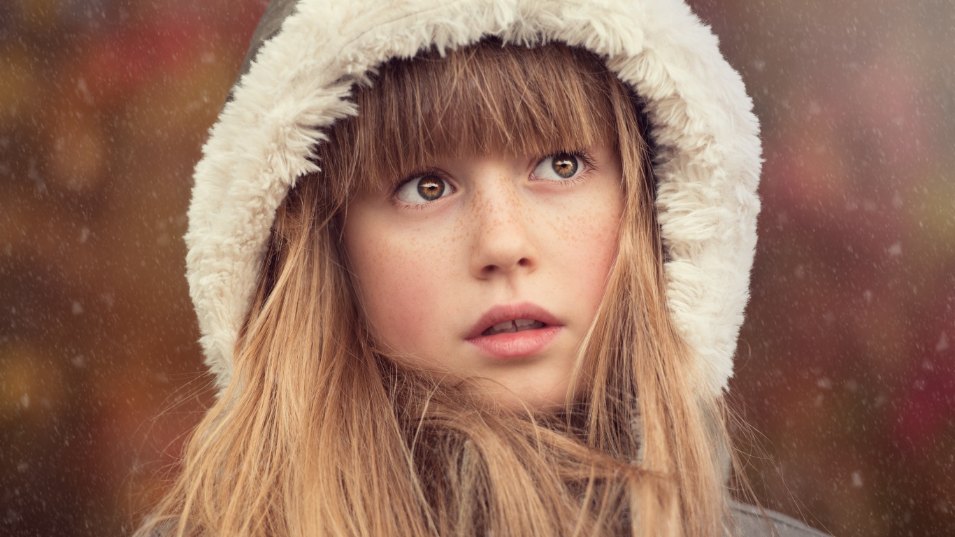 Маленькая девочка с веснушками на лице в капюшоне 