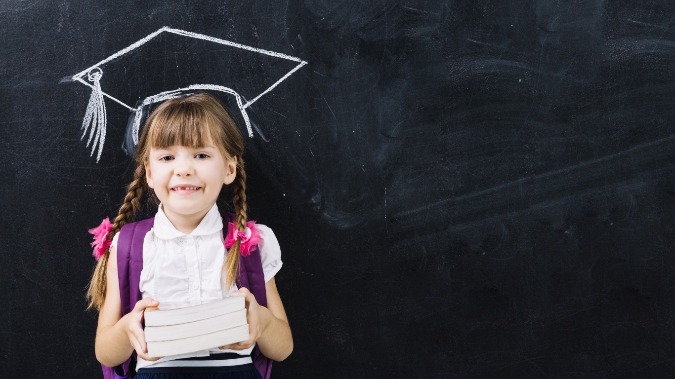 Маленькая школьница с книгами у доски 