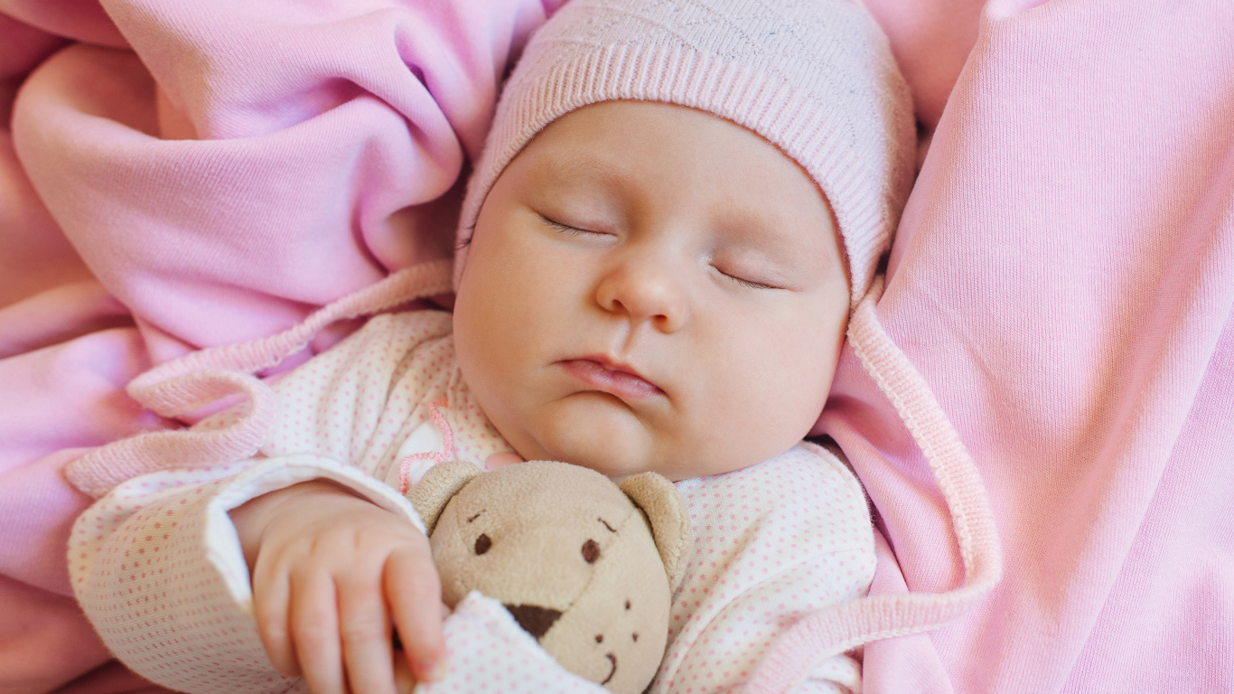 Спящий ребенок обнимает любимую игрушку