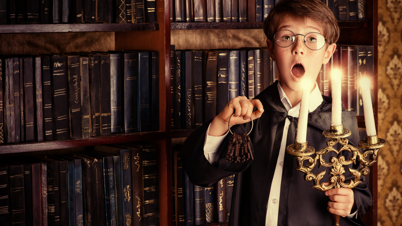Удивленный мальчик с подсвечником со свечами в библиотеке