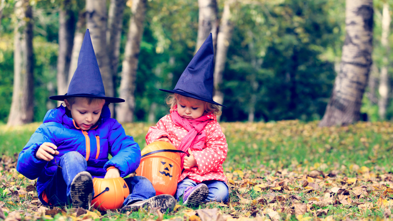 Маленькие мальчик и девочка в лесу на Хэллоуин 