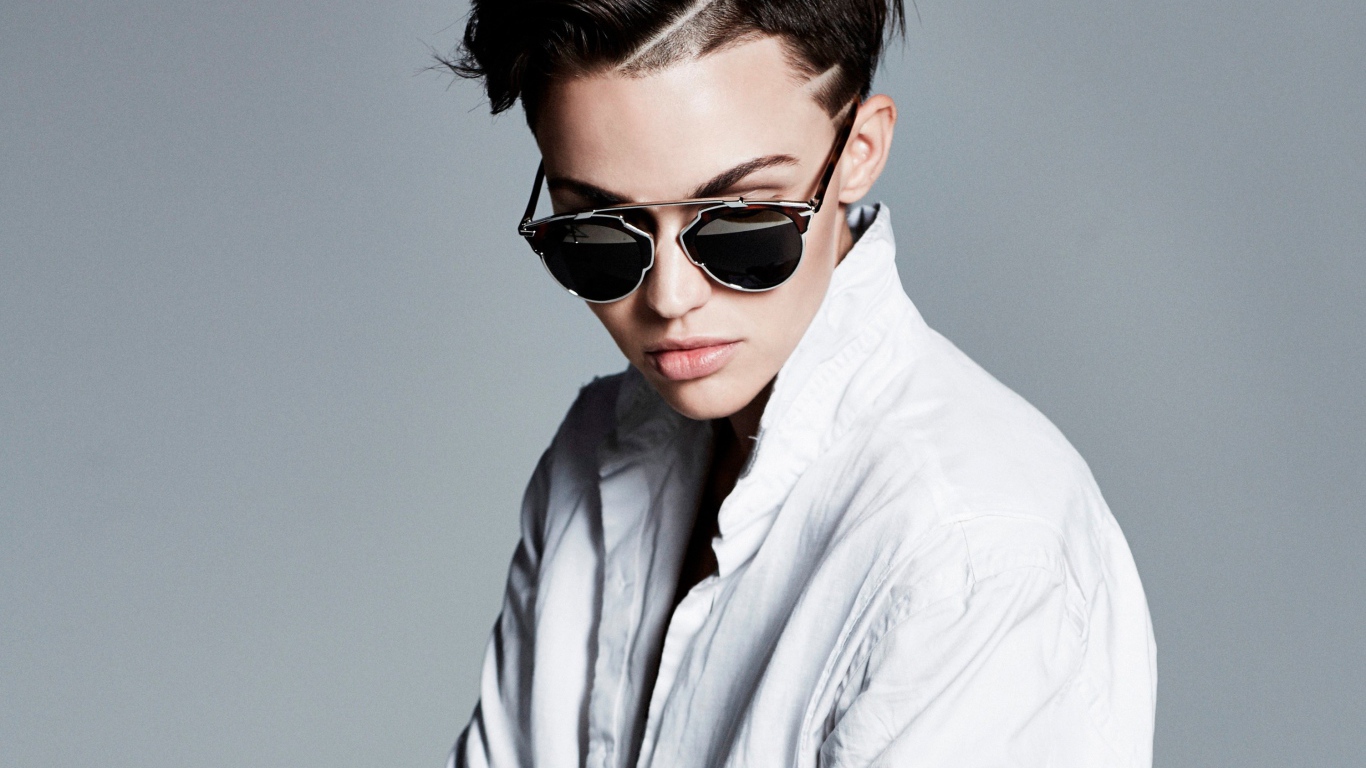 Актриса Руби Роуз в белой рубашке и очках на сером фоне