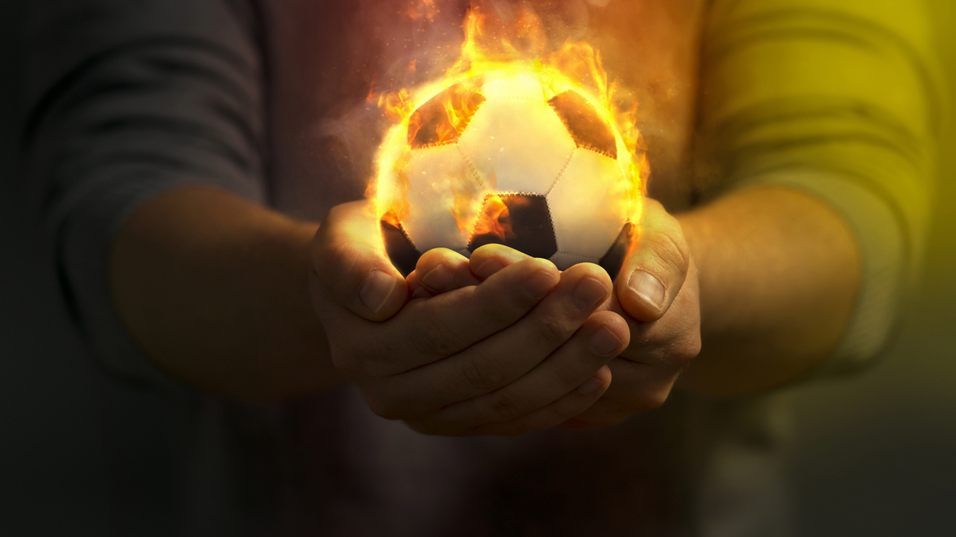 Огненный футбольный мяч в руках 