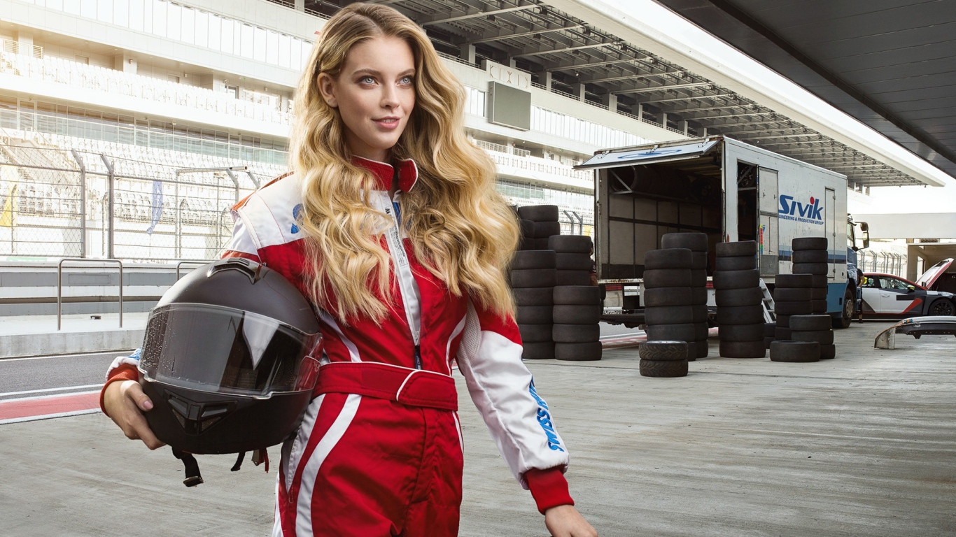 Девушка гонщица с шлемом в руках