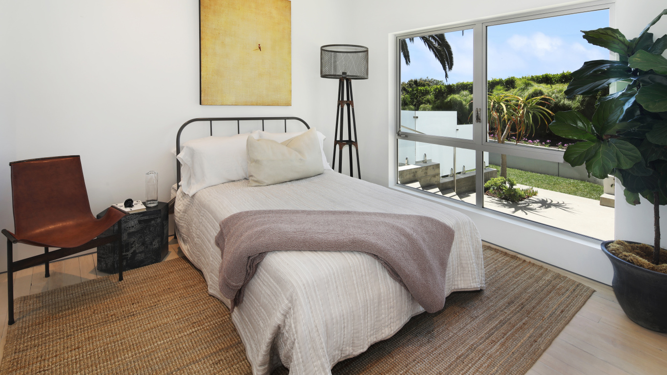 Большая кровать у окна в спальной комнате