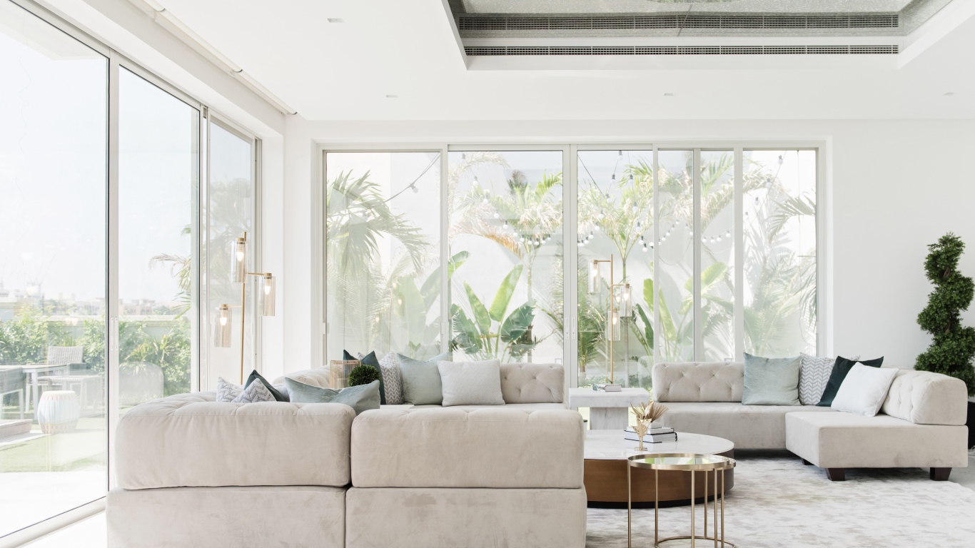 Большая гостиная комната с диваном и большими окнами