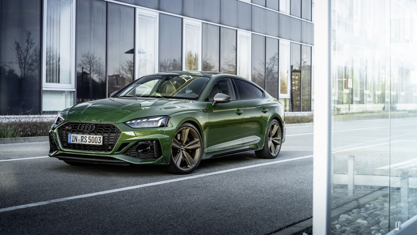 Зеленый автомобиль Audi RS 5 Sportback 2020 года у здания 
