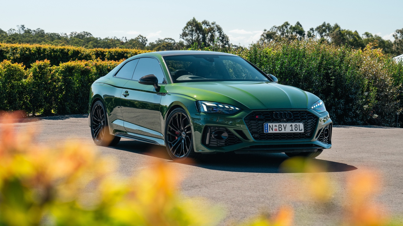 Зеленый автомобиль Audi RS 5 Coupé 2020  года в лучах солнца