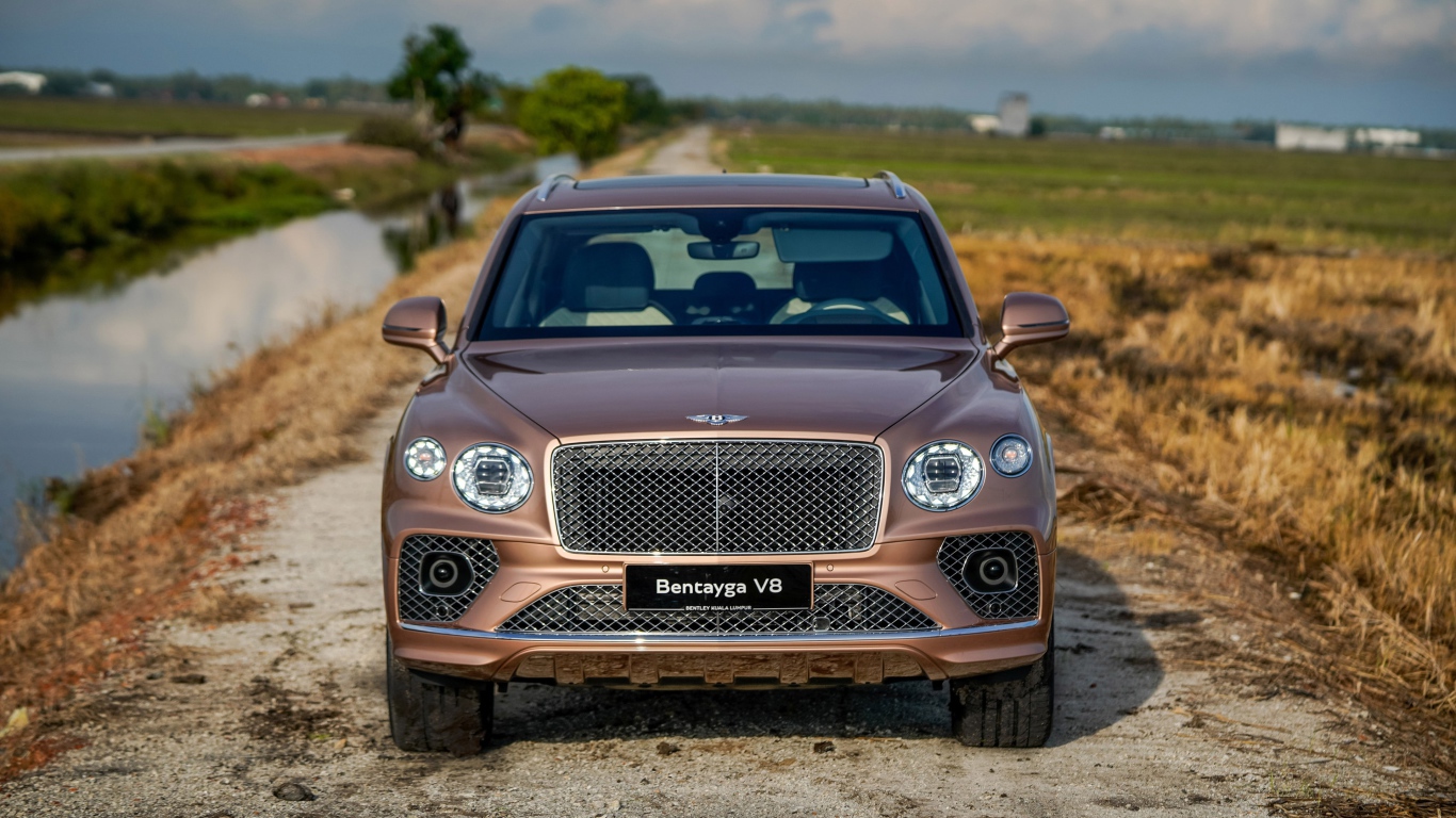 Коричневый автомобиль Bentley Bentayga V8 2020 года у реки
