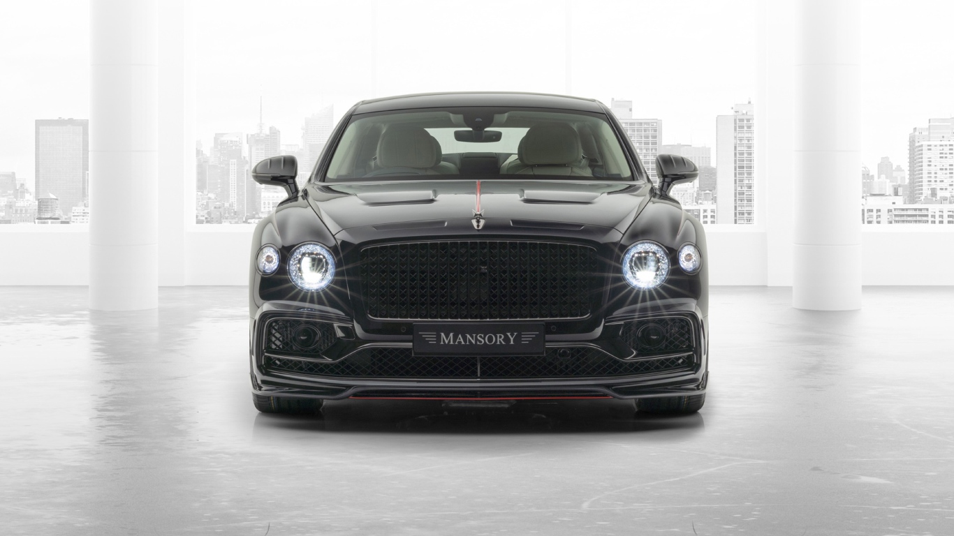 Черный автомобиль Mansory Bentley Flying Spur 2020 года с включенными фарами 