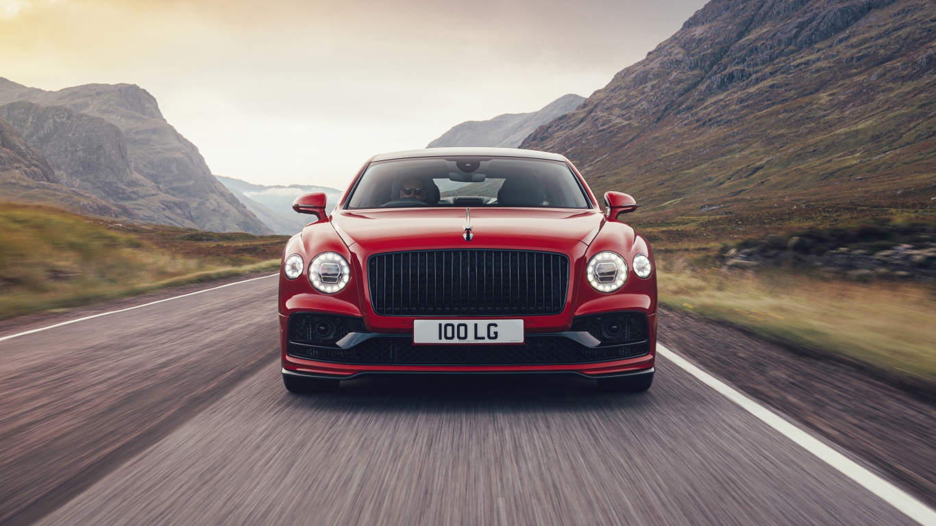 Red 2020 Bentley Flying Spur V8 car on the road in the mountains