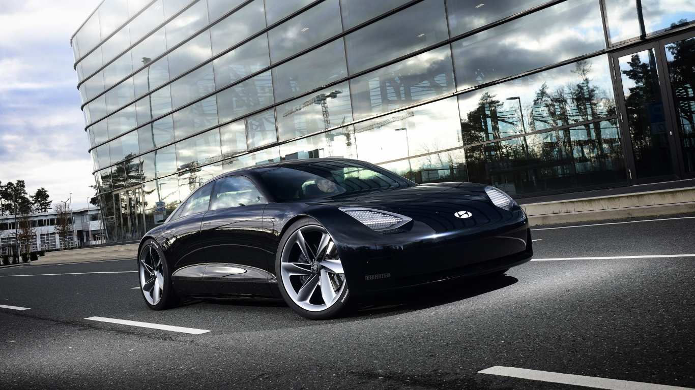 Черный автомобиль Hyundai Prophecy 2020 года у стеклянного здания 