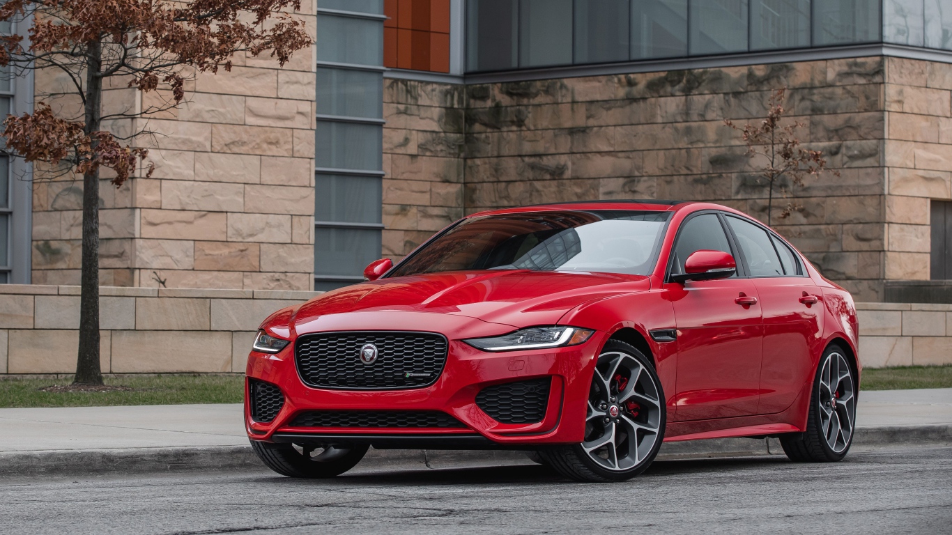 Красный автомобиль Jaguar XE P300 R-Dynamic, 2020 года у здания
