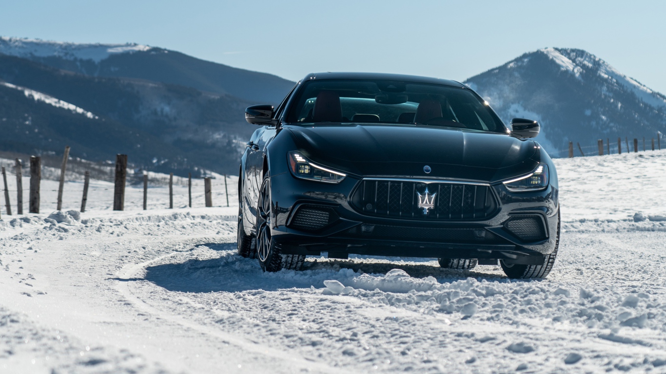 Черный автомобиль Maserati Ghibli S Q4, 2020 года едет по заснеженной дороге