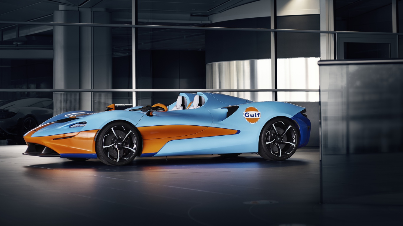 Спортивный автомобиль McLaren Elva Gulf Theme By MSO 2021 года у стеклянной стены 