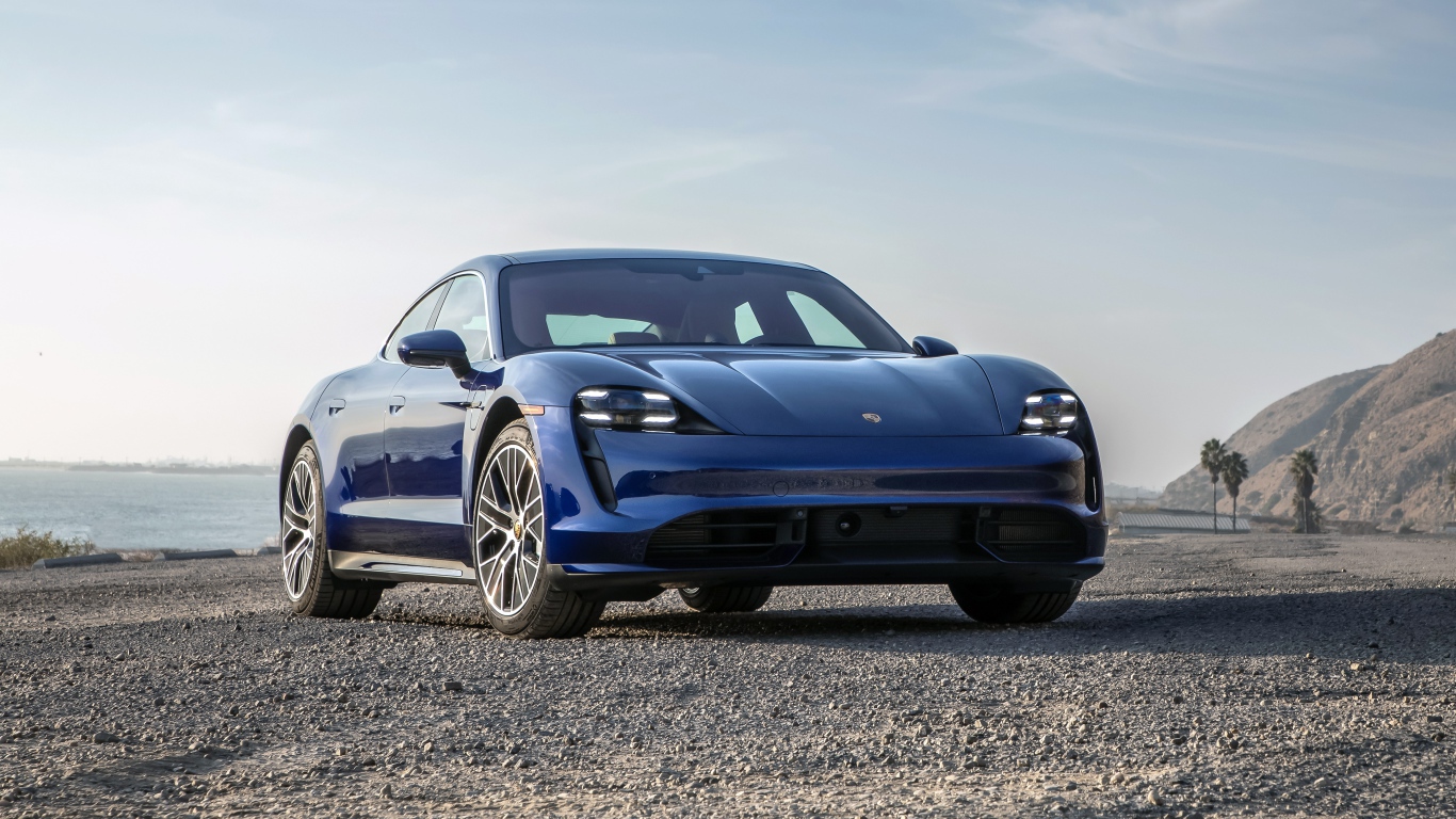 Синий автомобиль  Porsche Taycan Turbo, 2020 года у океана
