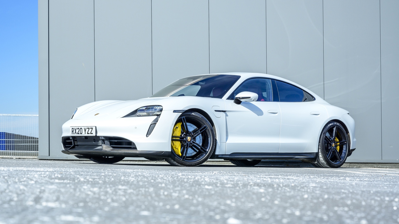 Белый автомобиль Porsche Taycan Turbo S 2020 года в лучах солнца 