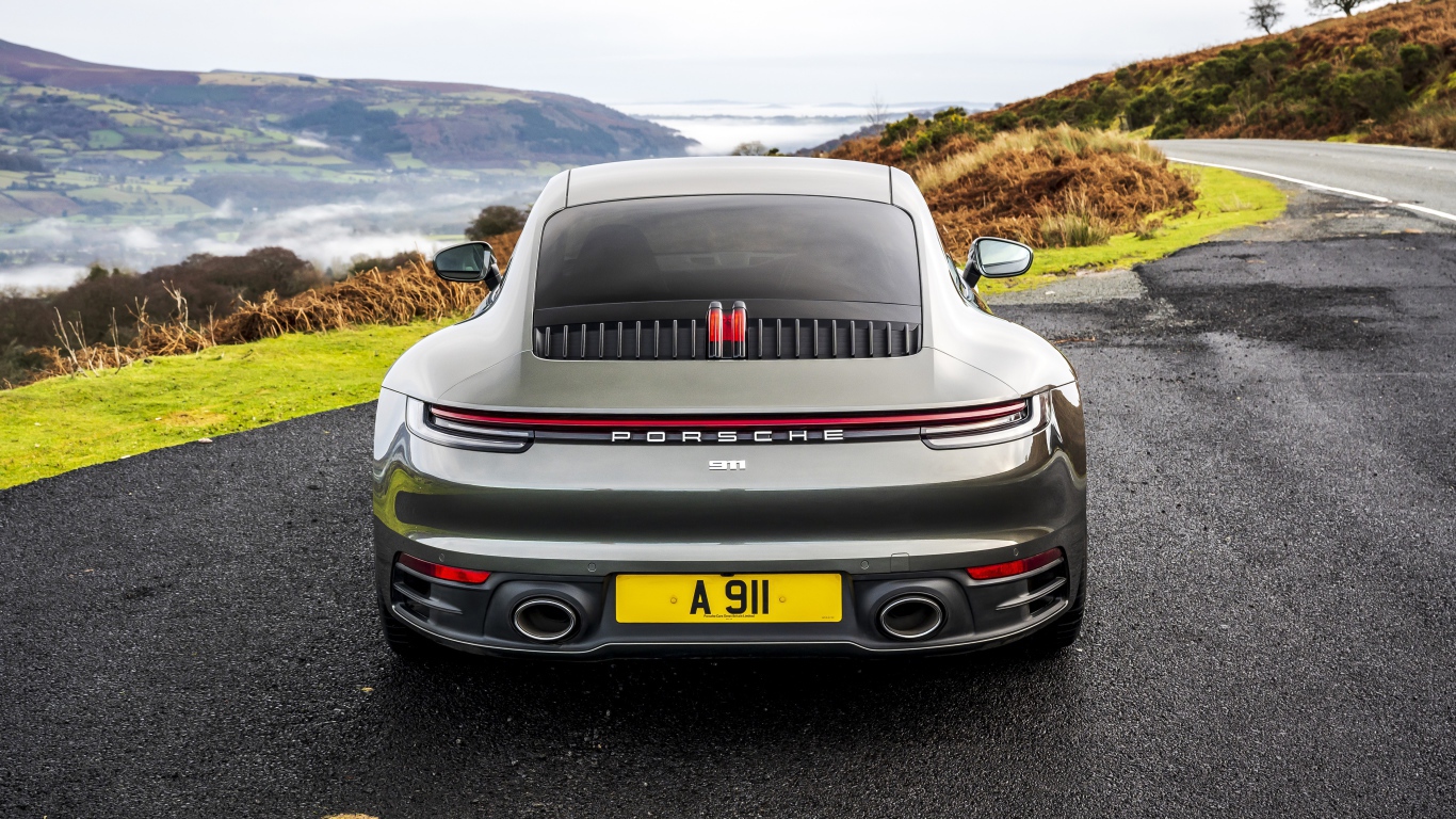 Автомобиль Porsche 911 Carrera на дороге у обрыва