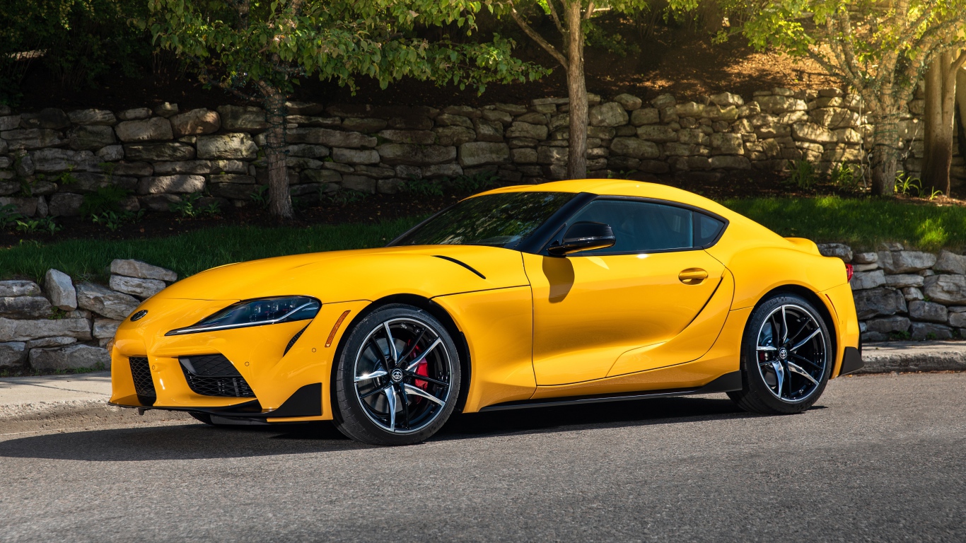 Желтый автомобиль Toyota GR Supra,ю 2021 года у стены