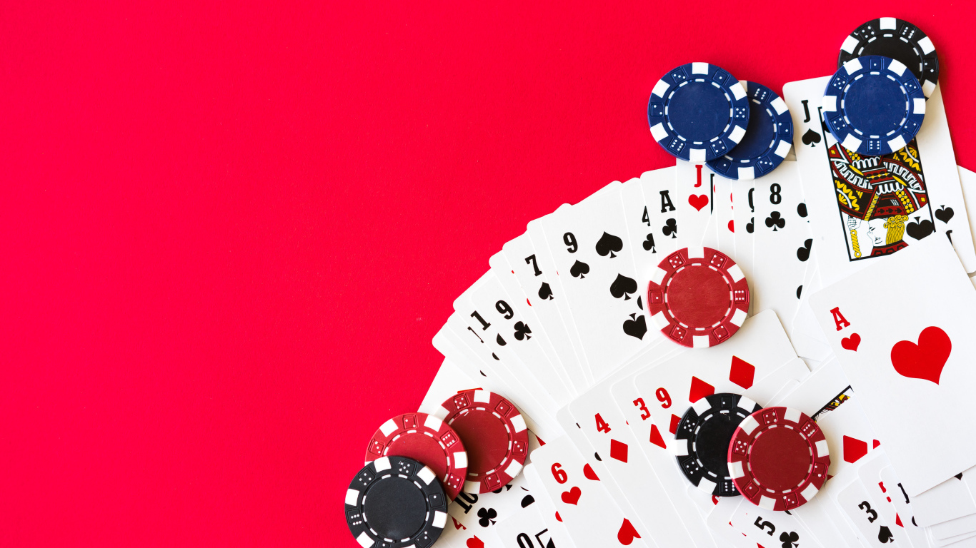 Колода карт и фишки для игры в покер на красном фоне