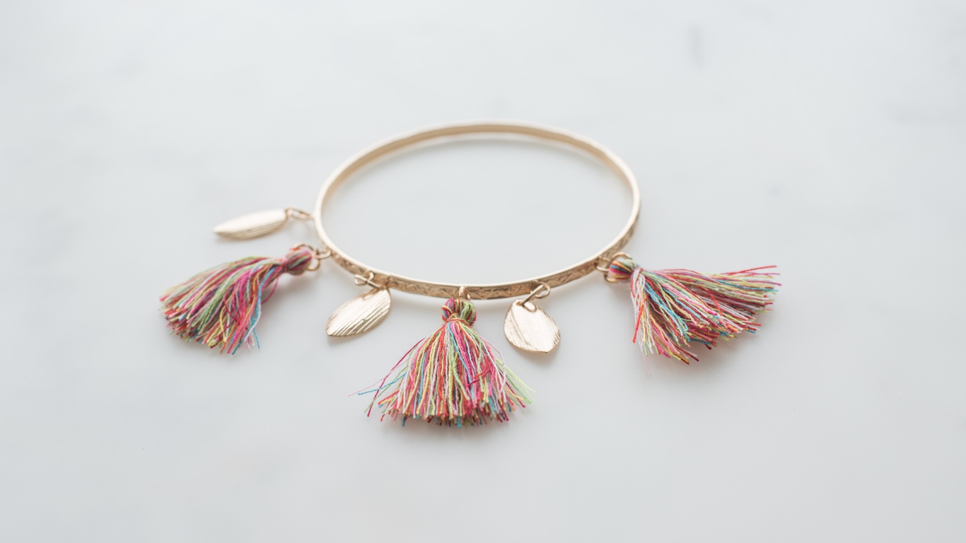 Золотой браслет на сером фоне