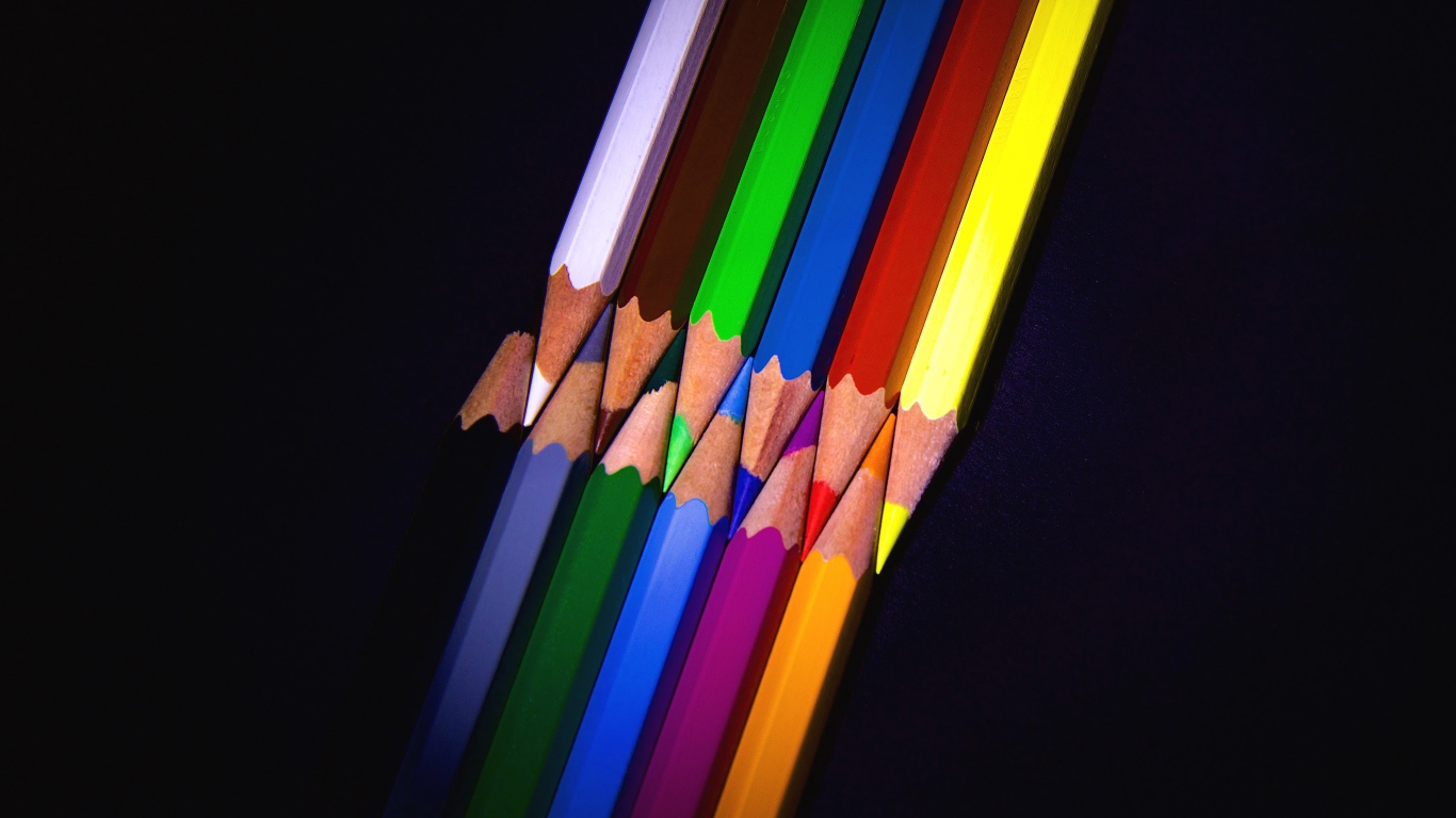 Разноцветные острые карандаши на черном фоне