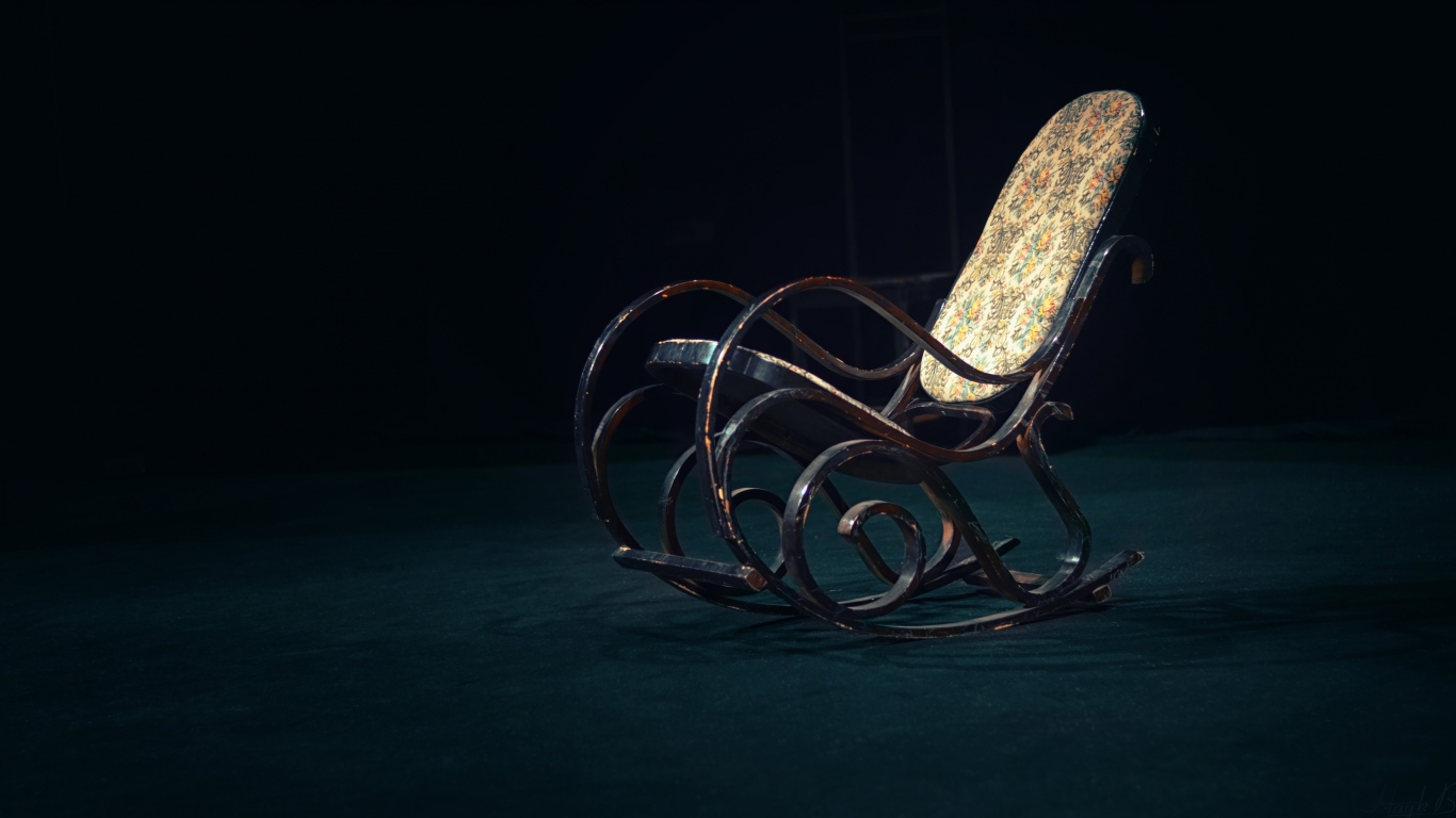 Старое кресло - качалка в темной комнате 