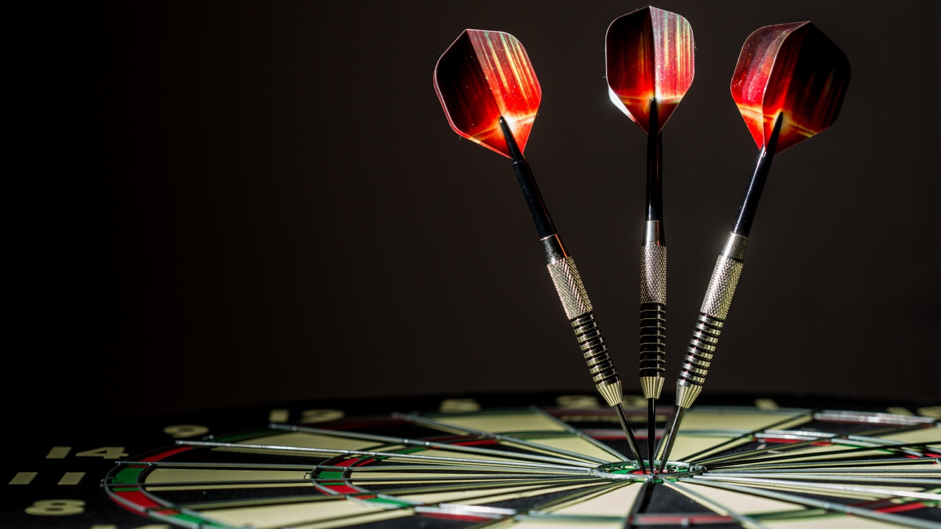 Три дротика в доске для дартс 