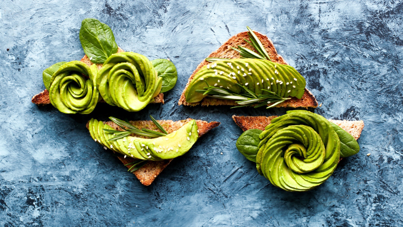 Хлеб с авокадо и базиликом на столе 