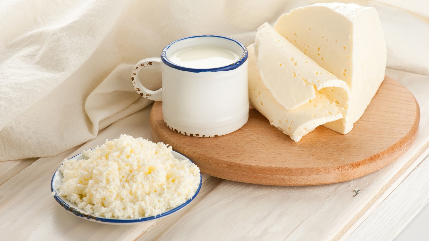 Творог, сыр и кружка молока на столе 
