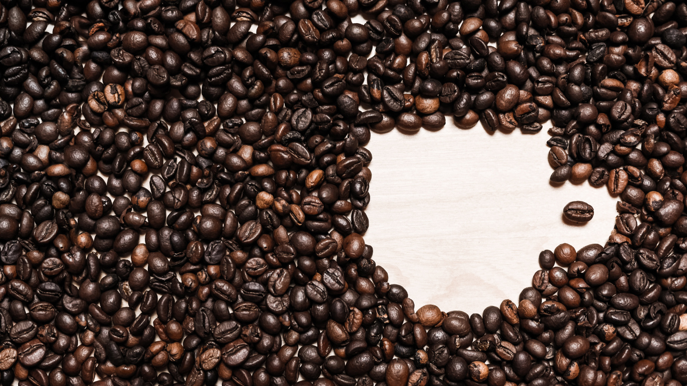 Рисунок чашки из кофейных зерен на столе