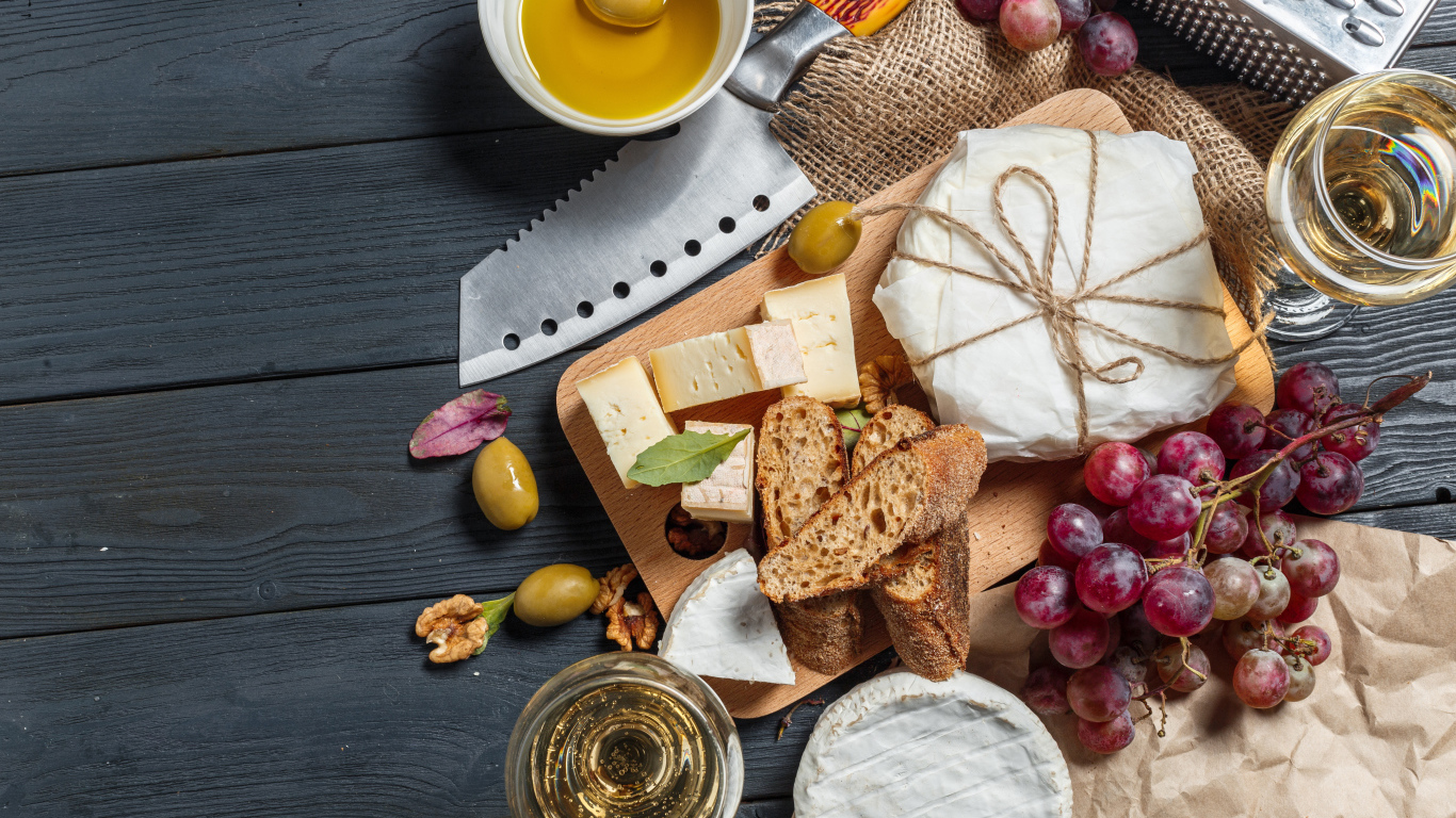Виноград на столе с сыром, хлебом и оливками