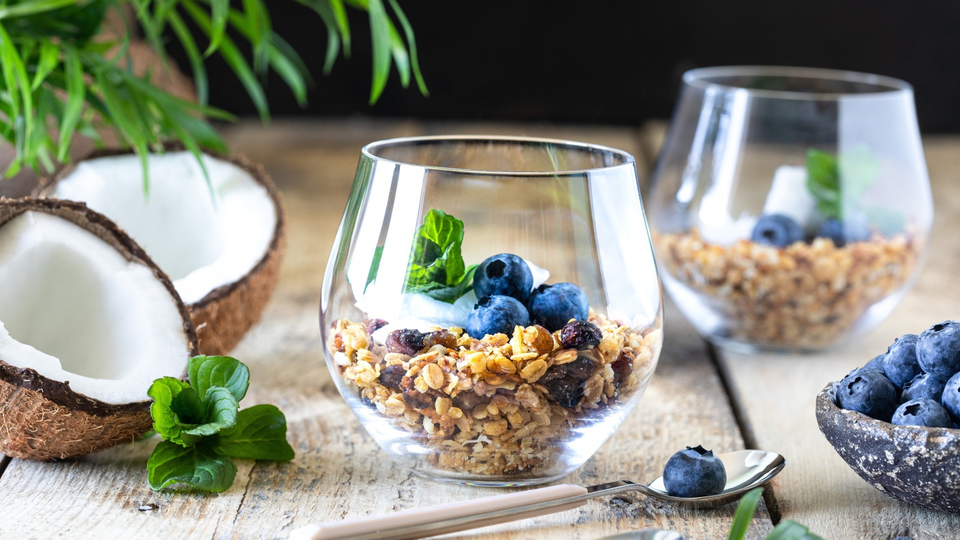 Мюсли с ягодами черники на столе с кокосом