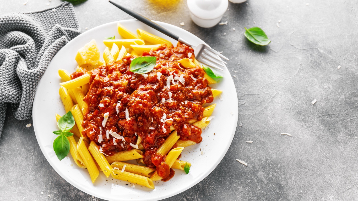 Макароны с соусом на белой тарелке